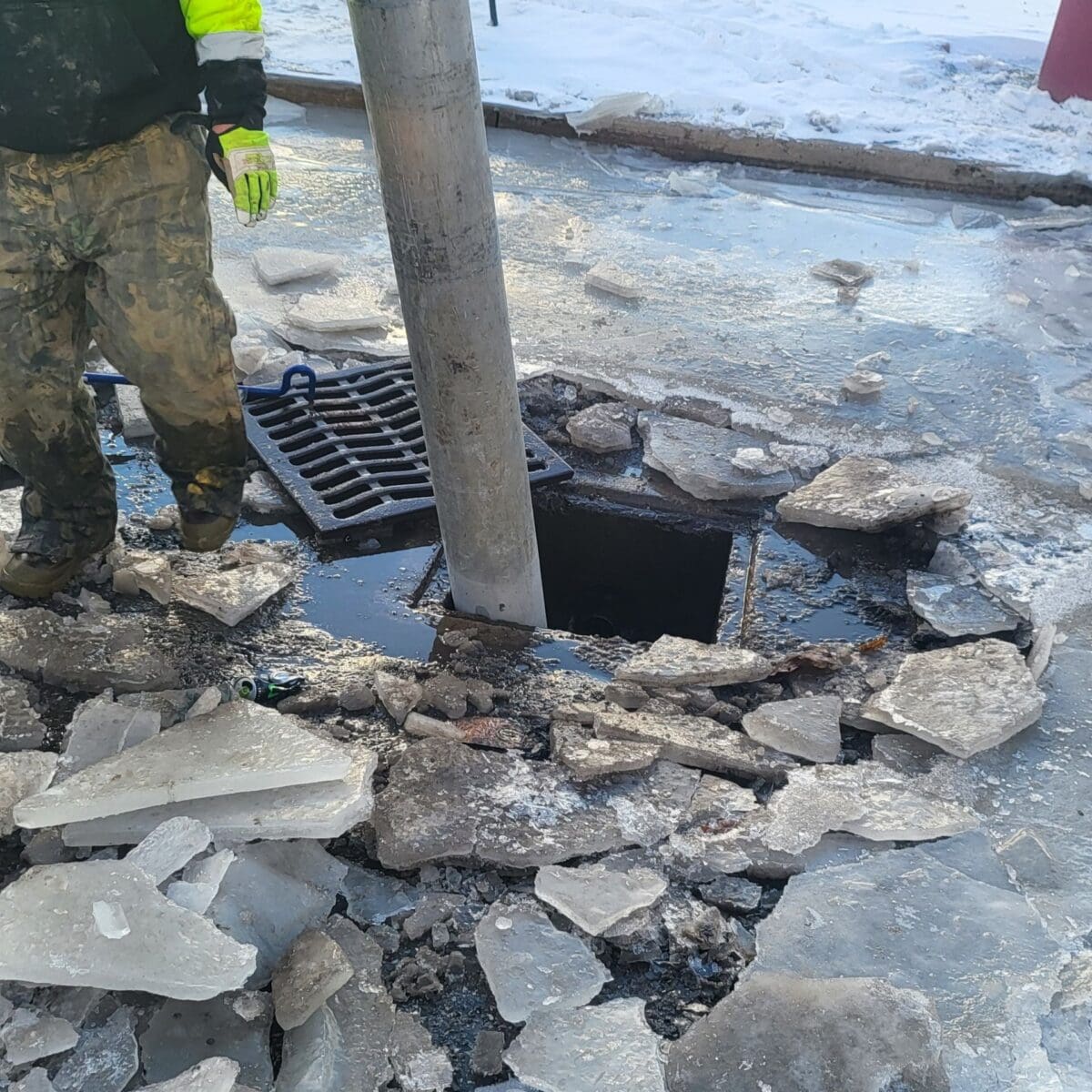 AQUALIS employee inspecting a catch basin