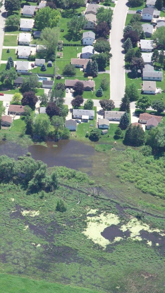 aerial view of some floods happening right beside some suburban houses