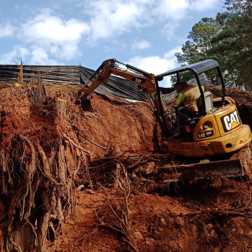 excavator on mound of dirt