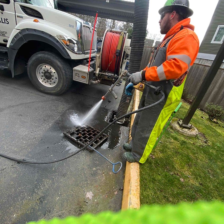 AQUALIS employee hydro jetting a sewer grate
