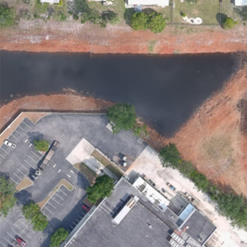 aerial view of a pond behind a parking lot