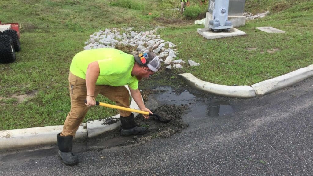 person shoveling beside a rip rap
