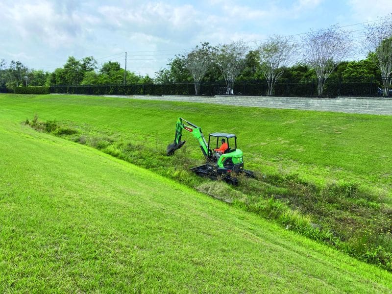 person on an excavator in an empty pond