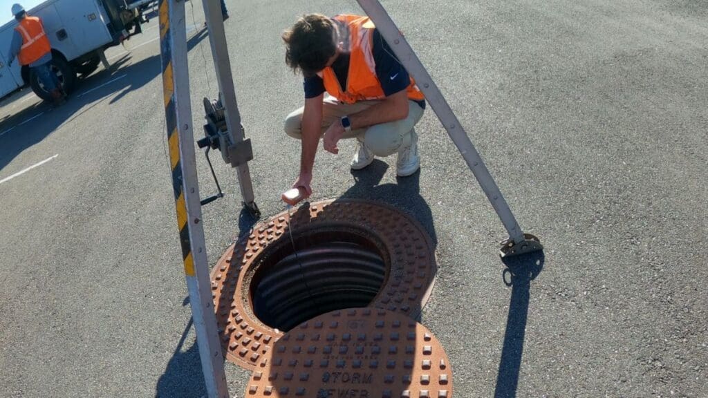 person inspecting a storm sewer